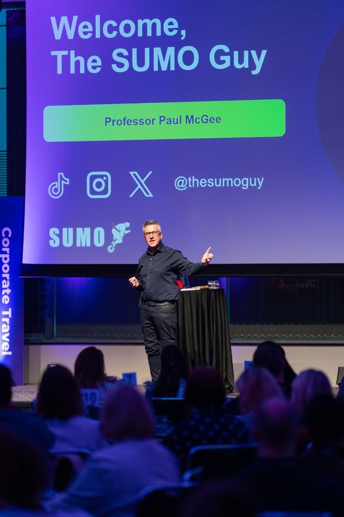 Paul McGee speaking on stage at the Corporate Travel Summit