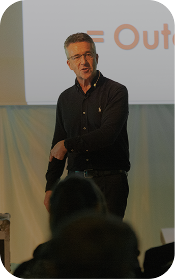 Paul McGee speaking on stage to an audience