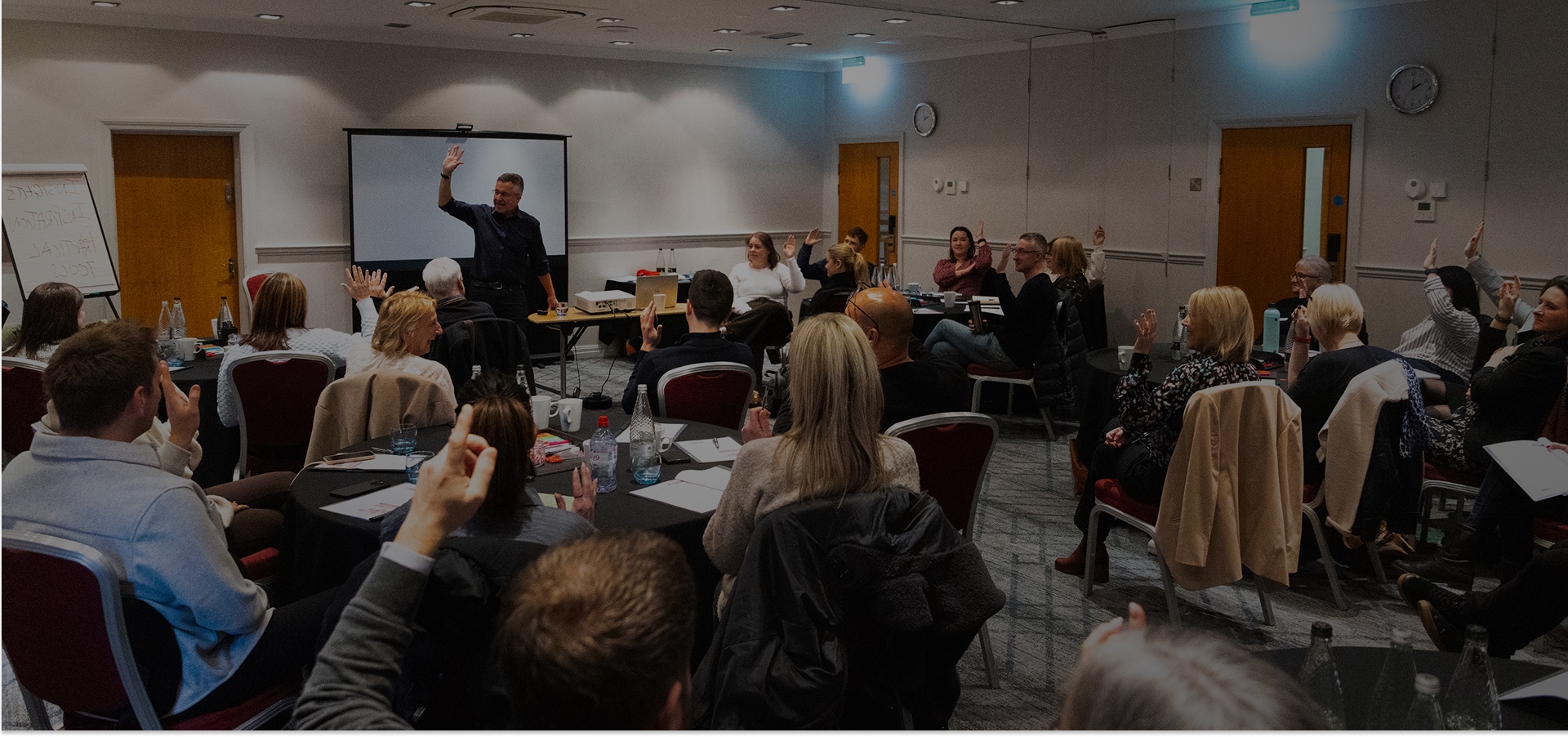 Paul McGee leading a presentation masterclass with participants raising their hands
